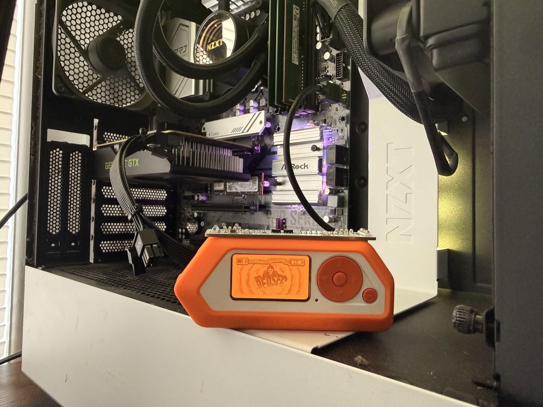 My Flipper Zero with its attachment in front of my desktop PC